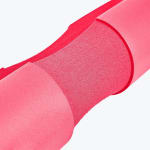 Close-up of a pink foam barbell pad with a textured grip section in the middle, isolated on a white background.