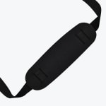 A close-up of a black padded shoulder strap cushion threaded with a black nylon strap on a white background.