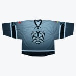 A grey and black gradient hockey jersey with a skull raider logo on the chest, a Canadian flag on the right shoulder, and a British Columbia flag on the left shoulder.