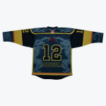 Back view of a custom teal and gold hockey jersey with the name Carosella, number 12, and gargoyle graphics.
