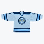 A light blue hockey jersey with dark blue stripes and a circular logo in the center that reads ESKIMO BROTHERS with two cartoon characters.