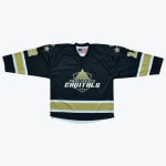 A black hockey jersey with the Providence Capitals logo, featuring gold and white stripes on the sleeves and hem, and gold stars on the shoulders.