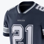 Close-up of a navy blue Dallas Cowboys NFL jersey with the number 21 printed on the front in white and silver, featuring the team name COWBOYS below the striped V-neck collar.