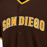 Close-up of a brown San Diego Padres baseball jersey with SAN DIEGO written in yellow letters with a white outline across the chest.