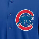 Close-up of a royal blue Chicago Cubs baseball jersey featuring the team logo of a blue bear cub inside a red C.