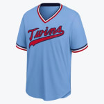 A light blue Minnesota Twins baseball jersey with red script lettering and striped trim on the collar and sleeves.