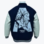 Back view of a navy blue varsity jacket with cream sleeves, featuring a large embroidered roaring tiger inside a stylized letter A and the text URBANO All Stars below it.