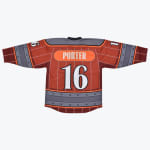 The back of a reddish-brown custom hockey jersey with PORTER and the number 16 printed on it, featuring a wooden barrel and riveted metal band design.
