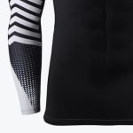 Close-up of a black athletic compression shirt with a black and white patterned long sleeve featuring chevrons and dots.