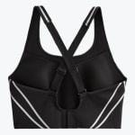Back view of a black sports bra with adjustable criss-cross straps, white stripe accents, and a hook-and-eye closure.
