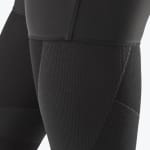 Close-up of the textured fabric and stitching on a pair of black compression leggings.