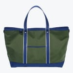 An olive green canvas tote bag with royal blue handles, bottom, and trim, featuring white stripes on the handles and a small front pocket.
