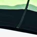 Close-up of a black and neon yellow jacket with a vertical zipper and a reflective striped pattern across the middle.