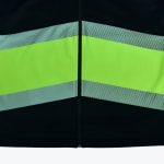 Close-up of a black safety jacket with a bright neon green band and reflective striped borders divided by a central zipper.