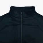 Close-up of a black mock neck jacket with a central zipper and structured chest seams against a white background.