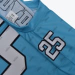 Close-up of a light blue addos jersey showing the number 25 on the sleeve.