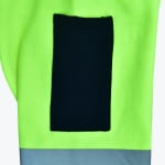Close-up of a neon green safety vest or jacket with a black rectangular pocket and a grey reflective band at the bottom.
