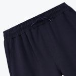 Close-up of a navy blue elastic waistband with a matching drawstring tied in the center.