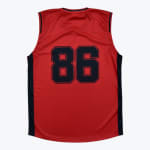 Back view of a red sleeveless basketball jersey with the number 86 in dark blue block letters and dark blue side panels.