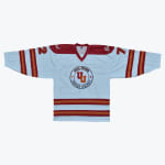 A white Utica-Fraser Unified Hockey jersey with red and orange stripes and the number 27 on the shoulders.