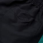 Close-up of a black pocket on a pair of shorts with an elastic waistband and reinforced stitching.
