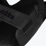 Close-up view of a black Addos shoulder sling showing the branded strap, velcro closure, and stitching details.