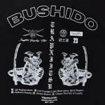 A black graphic tee design featuring the word BUSHIDO in bold white letters, two samurai warriors holding katanas, vertical text reading TRAPXJITSU, and a list of the seven Bushido virtues at the bottom.