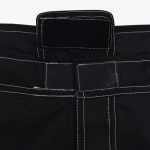 Close-up of a black waistband with white contrast stitching and a hook-and-loop Velcro closure flap.
