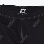 Close-up of black athletic shorts showing the white Figure and Form logo on the waistband and white contrast stitching.