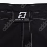 A close up shot of the waistband of black athletic shorts featuring white contrast stitching and a rectangular patch with the FIGURE & FORM logo.