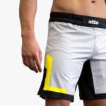 Close-up of a man wearing gray, black, and neon yellow Addos athletic shorts.