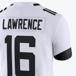 Close-up of the back of a white football jersey with LAWRENCE and the number 16 in black.
