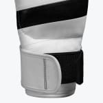 Close-up of a white leather boxing gloves wrist strap with a black velcro closure and double stitching.