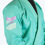 Close-up of a mint green Jiu-Jitsu gi sleeve featuring a retro pastel purple and light green Addos logo patch.