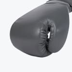 Close-up of a charcoal grey leather boxing glove showing the thumb stitching and matte finish against a white background.