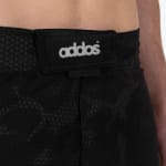 Close-up of the waistband of black patterned boardshorts featuring a black patch with the white logo Addos and a registered trademark symbol.