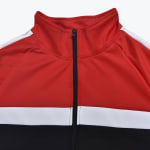Close-up of a red, white, and black zippered track jacket with a high collar.