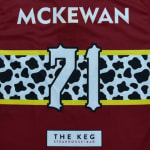Back of a maroon sports jersey with the name MCKEWAN and the number 71 over a cow print stripe, featuring The Keg Steakhouse + Bar logo at the bottom.