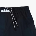 Close-up of black athletic shorts with a white addos logo on the waistband and branded drawstrings.