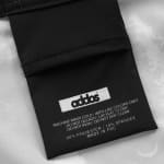 Close-up of a black fabric care label with the brand name addos and washing instructions printed in white text.
