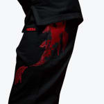 Close-up of black Addos BJJ gi pants featuring a large, detailed red embroidered koi fish on the thigh.