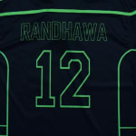 The back of a dark sports jersey with the name RANDHAWA and the number 12 printed in neon green outline.