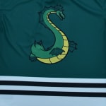 A stylized green sea serpent logo shaped like the letter S on a dark green jersey with black and white horizontal stripes.