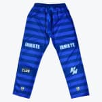 A pair of blue horizontally striped athletic pants with INMATE written on the thighs and various logos on the lower legs, set against a plain white background.