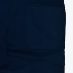 Close-up of a large patch pocket and cargo flap on navy blue utility pants.
