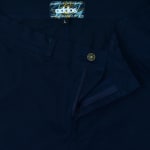 Close-up of the front waist, button, zipper, and brand label of navy blue workwear trousers.