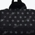 Close-up of a black bag with a repeating pattern of textured grey stars and a zipper.