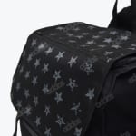 Close-up of a black fabric bag with a grey pattern of stars and the word printed repeatedly.