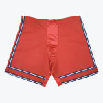 A flat lay of red athletic-style boxer shorts with blue and white stripes on the sides and bottom hem, set against a white background.