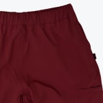 Close-up of the waistband and side pocket of a pair of maroon cargo shorts.